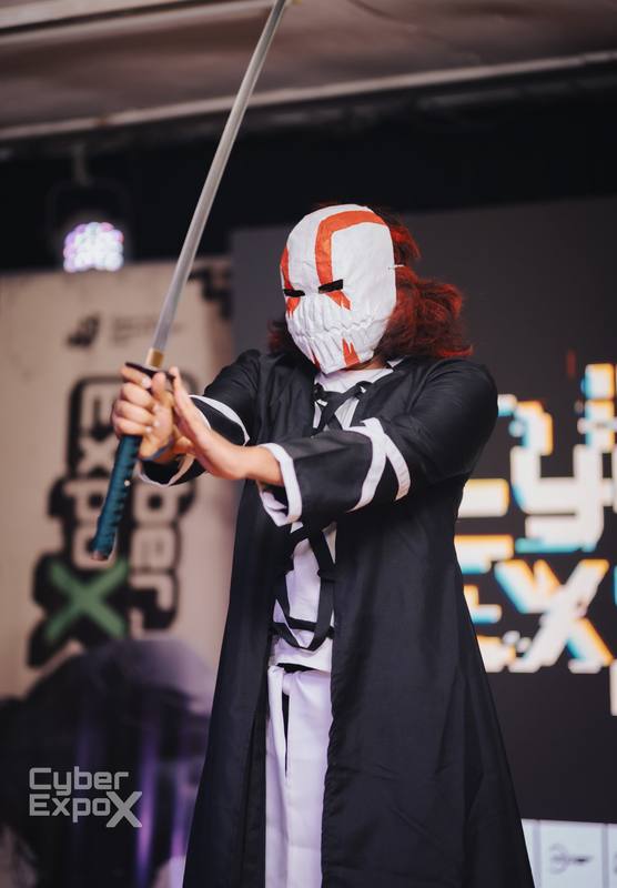 Masked cosplayer drawing a katana